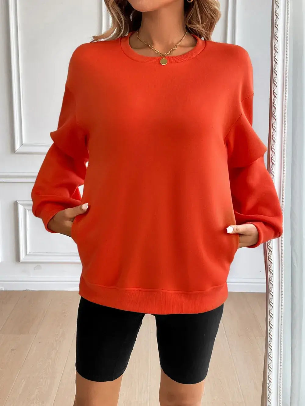 Ivy Lane round neck long sleeve sweatshirt in vibrant orange, designed for comfort and style, paired with black shorts.